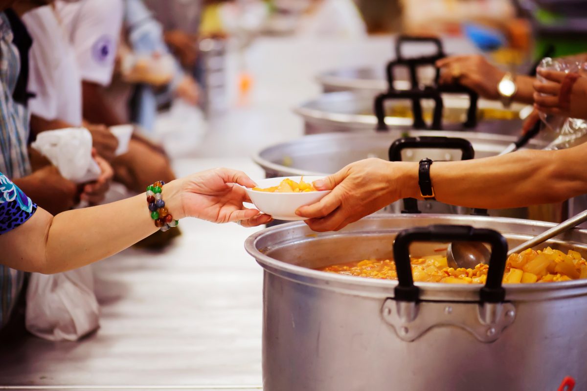 people helping to serve food in a kitchen